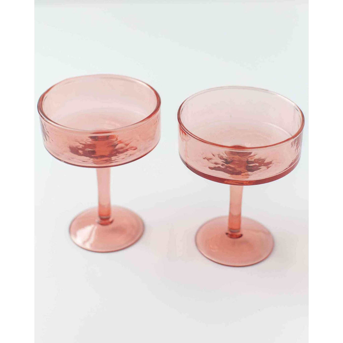 Blush Handblown Hammered Coupe Mixed Beverage Glasses are sold individually.