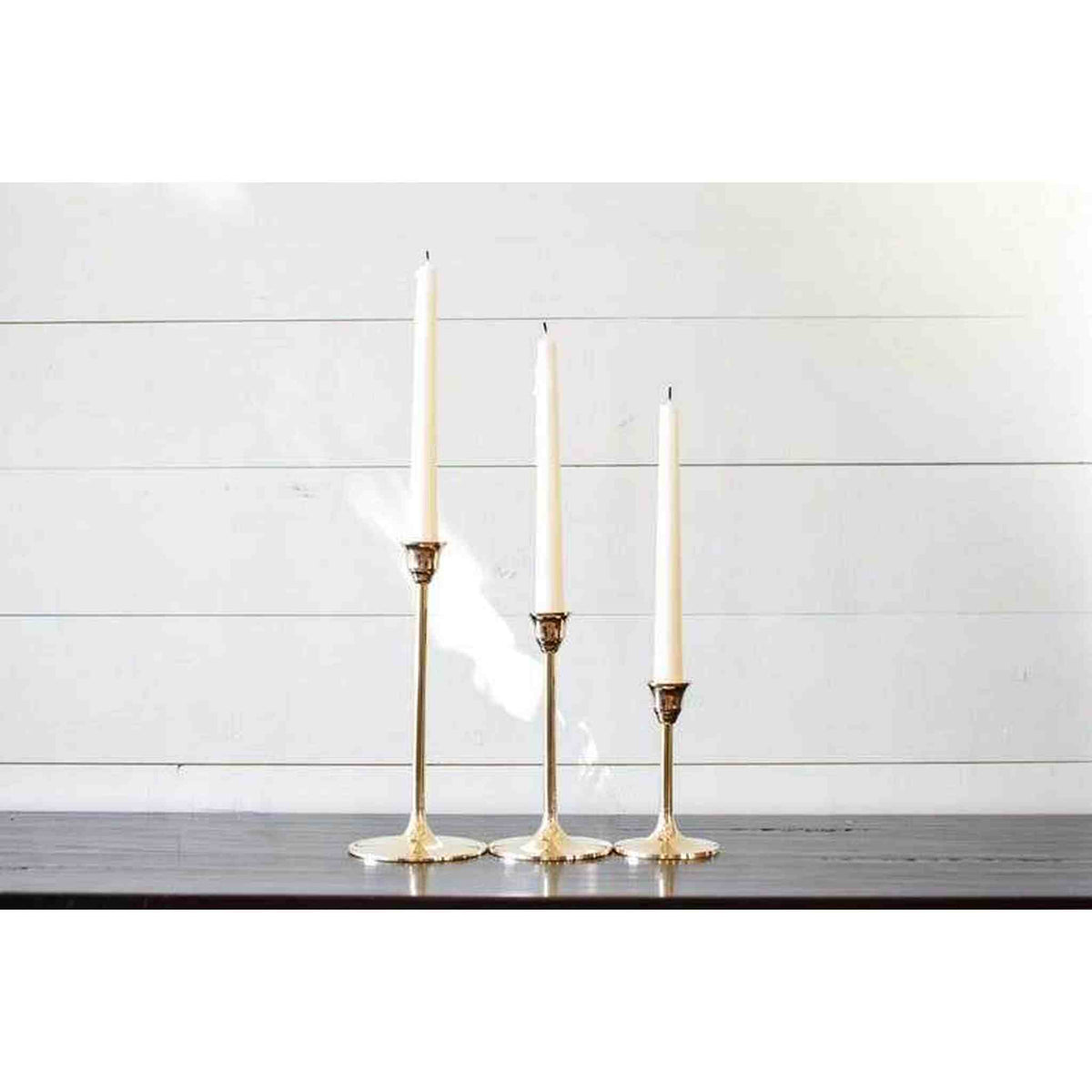 A set of three brass candlesticks.