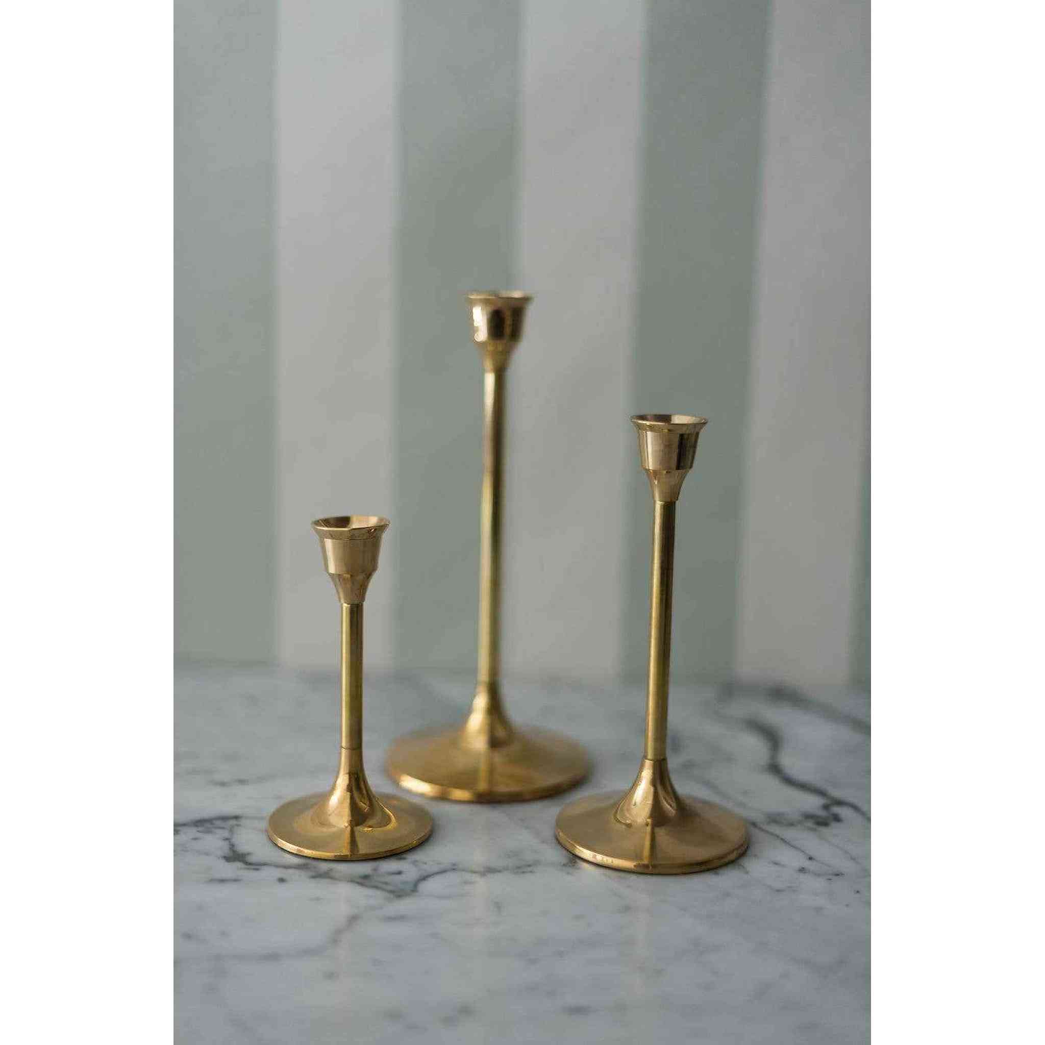 A set of three brass candlesticks.