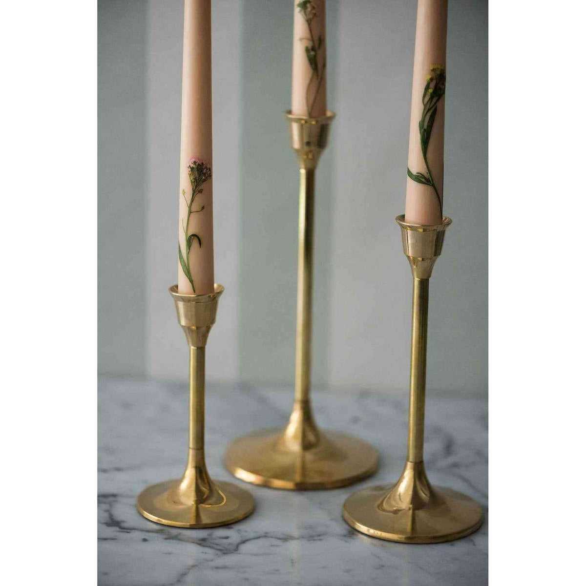 A set of three brass candlesticks.