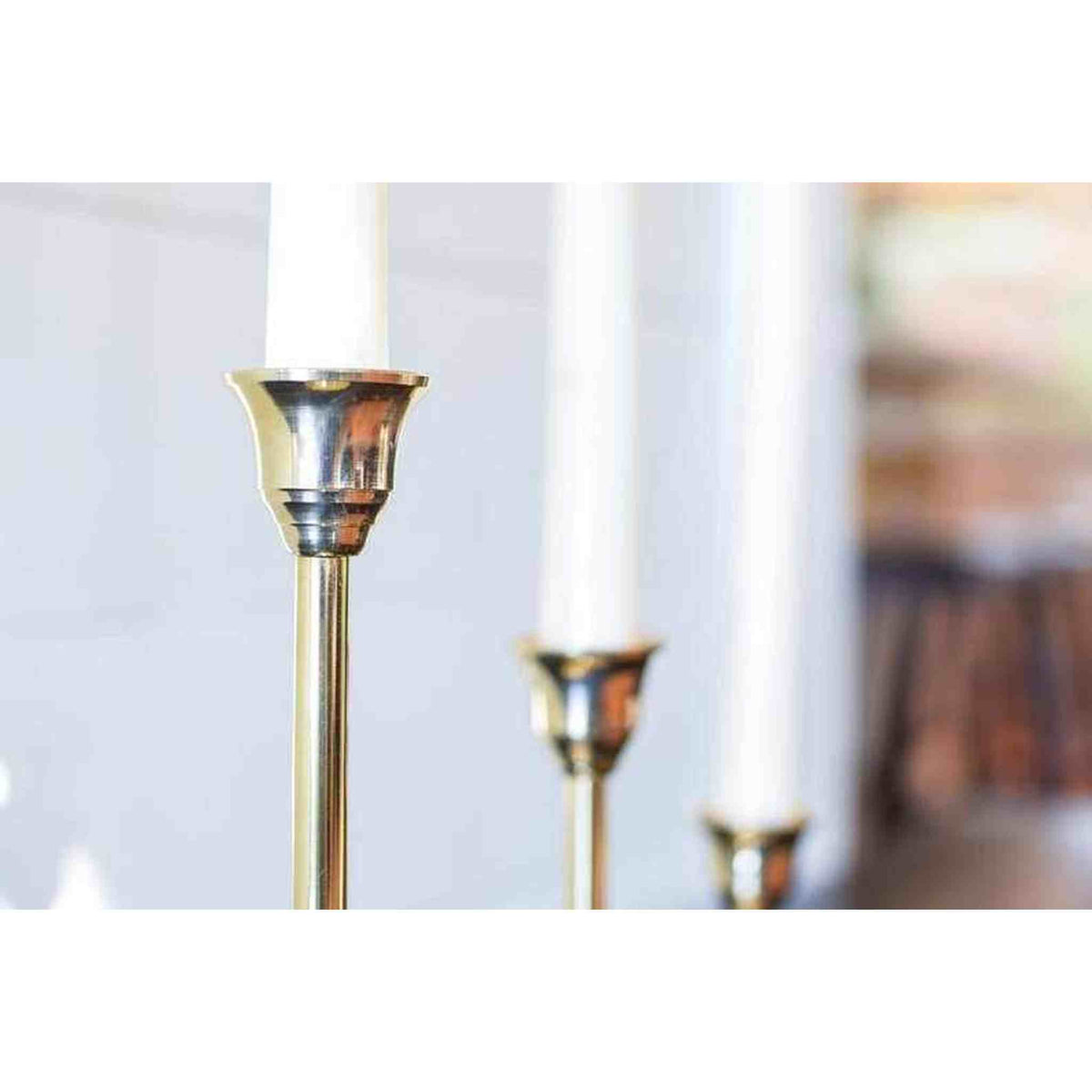 A set of three brass candlesticks.